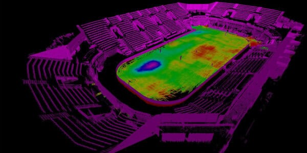 Oval stadium field shown as a false-color LiDAR point cloud, revealing a blue-to-red depression near one end; surrounding spectator stands rendered in magenta against a black background.