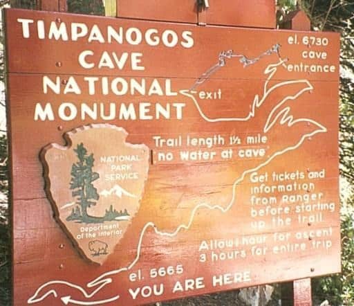 Wooden park sign identifies Timpanogos Cave National Monument, maps trail and cave entrance, and warns hikers about distance and timing at a forested trailhead.

Text in image:
TIMPANOGOS
CAVE
NATIONAL
MONUMENT

el. 6730
cave entrance

exit

Trail length 1½ mile
No water at cave

Get tickets and information from ranger before starting up the trail

Allow 1 hour for ascent
3 hours for entire trip

NATIONAL PARK SERVICE

Department of the Interior

el. 5665

YOU ARE HERE