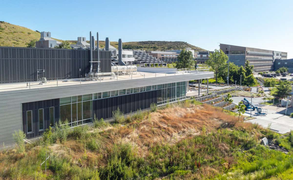July 16, 2023 - The Research and Innovation Laboratory (RAIL), on the National Renewable Energy Laboratory’s (NREL’s) South Table Mountain (STM) campus, is a flexible, multipurpose lab space to support growing cross-disciplinary research. Aerial view of the RAIL (left) looking northeast toward the heart of the campus. (Photo by Joshua Bauer and Bryan Bechtold / NREL)