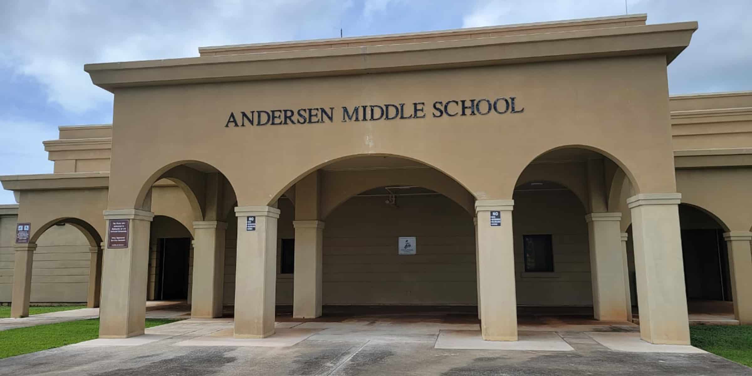 Andersen Middle School entrance stands with arched colonnade, three large arches and pillars framing a covered walkway; beige stucco façade under a cloudy sky, small grassy lawns.

Text: ANDERSEN MIDDLE SCHOOL